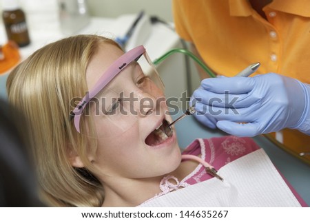 Closeup of a girl having her teeth examined at the dental clinic