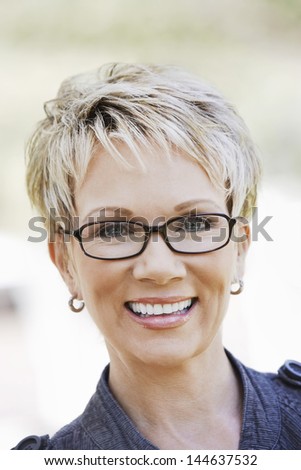 Closeup portrait of an elegant middle aged woman wearing glasses