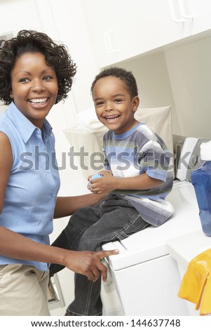 Cheerful African American mother and son in the laundry room