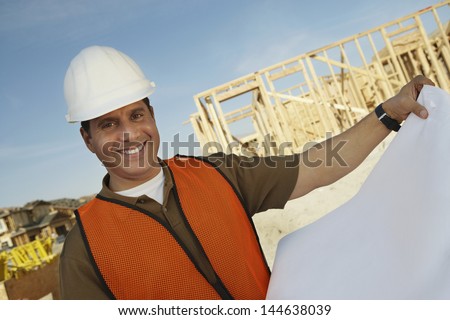 Closeup portrait of a smiling construction worker with blueprints