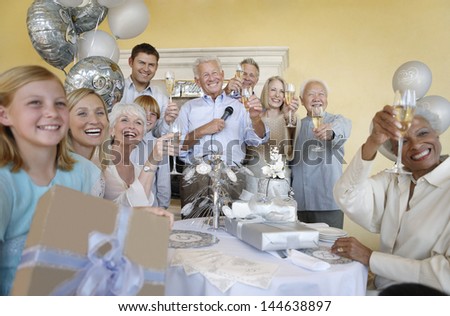Happy multiethnic family and friends toasting champagne in a party