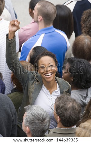 High angle view of a happy African American woman raising hands with people standing around