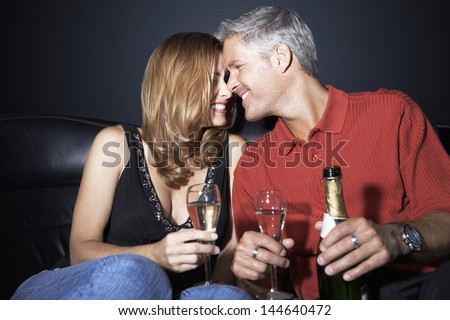 Romantic and happy couple with champagne flutes rubbing noses