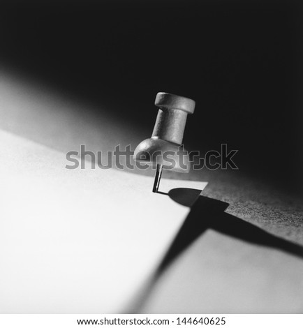 Push pin holding down paper (b&w) (close-up)
