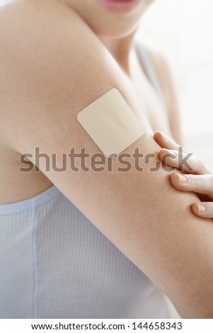 Midsection Woman With Nicotine Patch On Arm Over White Background