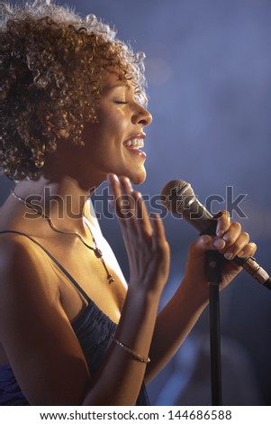 Closeup profile of a happy female jazz singer on stage