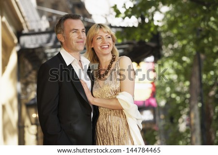 Elegant middle aged couple outside building on London street
