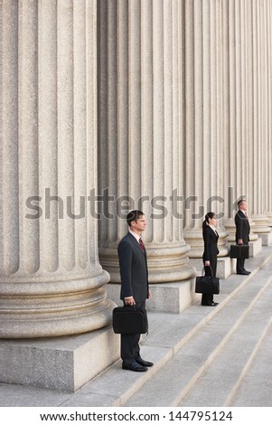 Full length side view of three attorneys waiting on courthouse steps