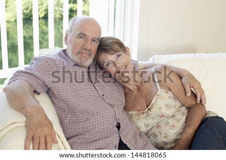 Portrait of a relaxed and loving middle aged couple sitting on couch