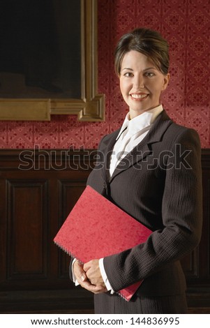 Portrait of smiling businesswoman holding book in conference room