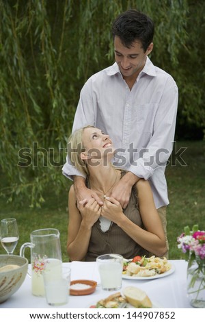 Happy romantic couple at dining table in garden
