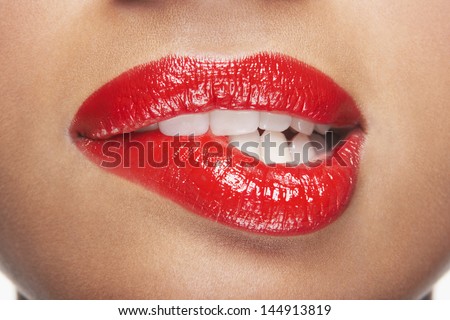 Closeup Of Sensuous Woman Biting Red Lips