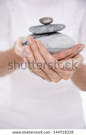Closeup midsection of a woman holding pile of stones
