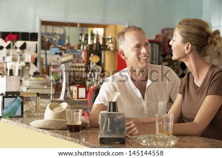 Happy middle aged couple sitting in bar