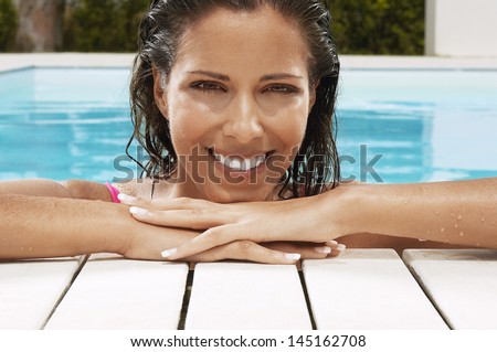 Portrait of pretty young woman smiling at poolside