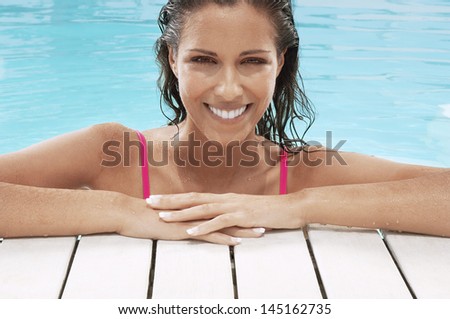 Closeup portrait of beautiful young woman smiling at poolside