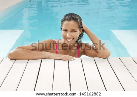 Portrait of young woman smiling at poolside