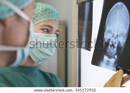 Closeup of two radiologists examining xray of skull