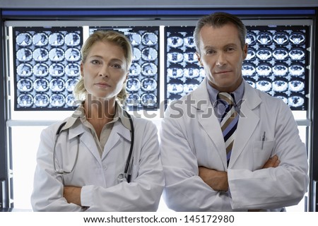 Portrait of a confident male and female doctors by brain scans in hospital