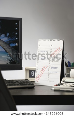 Calendar with marked holiday time on desk in office