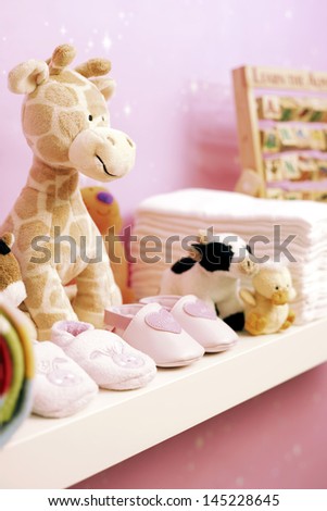 Stuffed toys shoes and nappies on shelf in baby\'s room