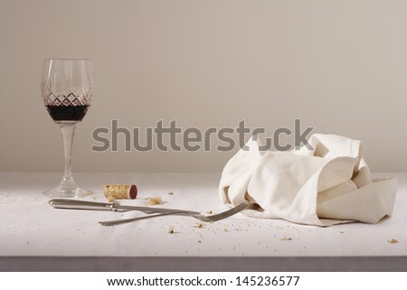 Wine glass cutlery dish cloth on messy table