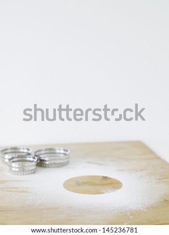 Pastry cutters and flour on table top elevated view