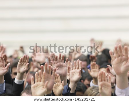 Closeup Of Business Crowd Raising Hands