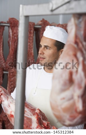 Butcher holding slab of meat in the meat locker