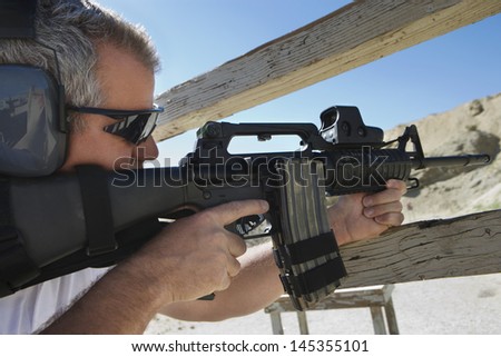 Man aiming machine gun at firing range