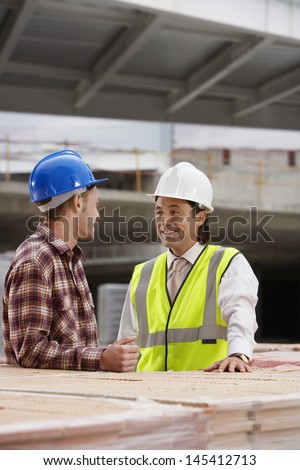 Smiling construction workers talking at the building site