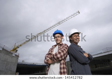 Portrait of two happy construction workers at building site