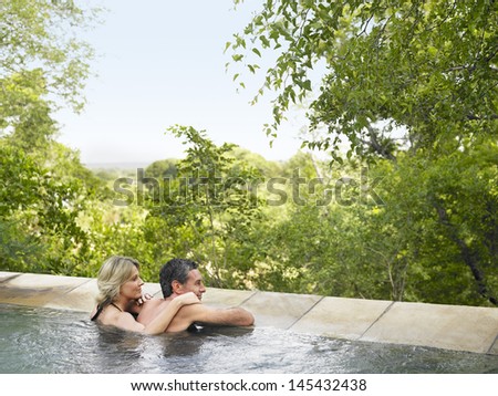 Rear view of an adult couple in pool looking at view