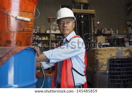 Middle-aged manager looking at something in warehouse