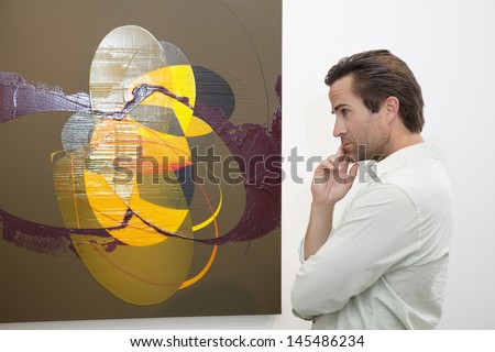 Thoughtful man looking at wall painting in art gallery