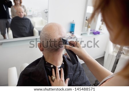 Man getting his head shaved in salon
