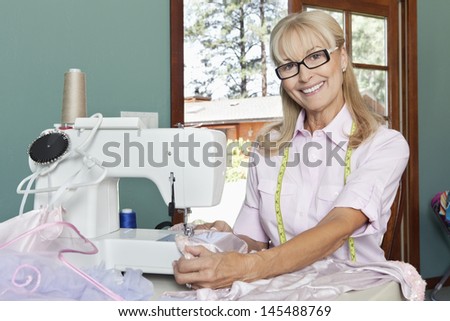 Portrait of a happy senior woman sewing