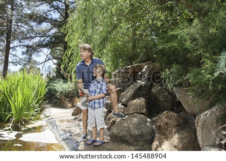 Mature man with son fishing at lake