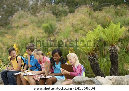 Young Children Preparing Notes On Clipboards During Field Trip