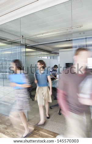 Full length of blurred office workers leaving conference room