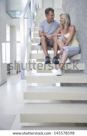 Full length of happy middle aged couple sitting on steps