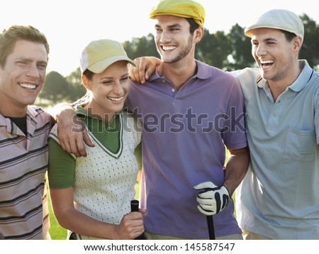 Cheerful Young Golfers With Arms Around On Golf Course