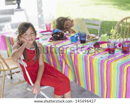 Portrait of a girl with boy sleeping at outdoor table after birthday party