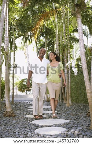 Full length of happy loving couple walking on path