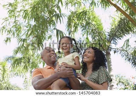 Portrait of smiling girl with parents enjoying in park