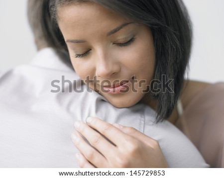 Closeup of a young woman hugging a man
