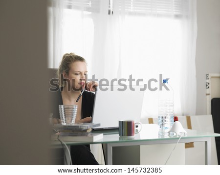 Young Woman Using Laptop In Home Office