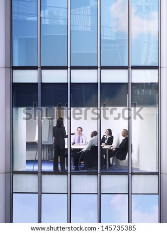 View of business people in conference room through window