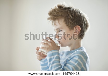 Side view of a young boy drinking milk