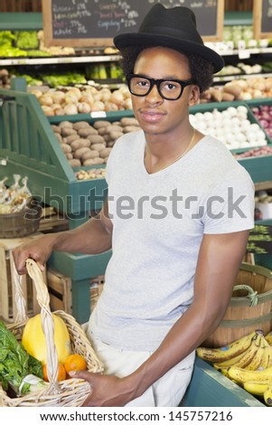Portrait of an African American man with vegetable basket at supermarket